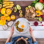 The woman at the dinner table with organic food , the view from the top.