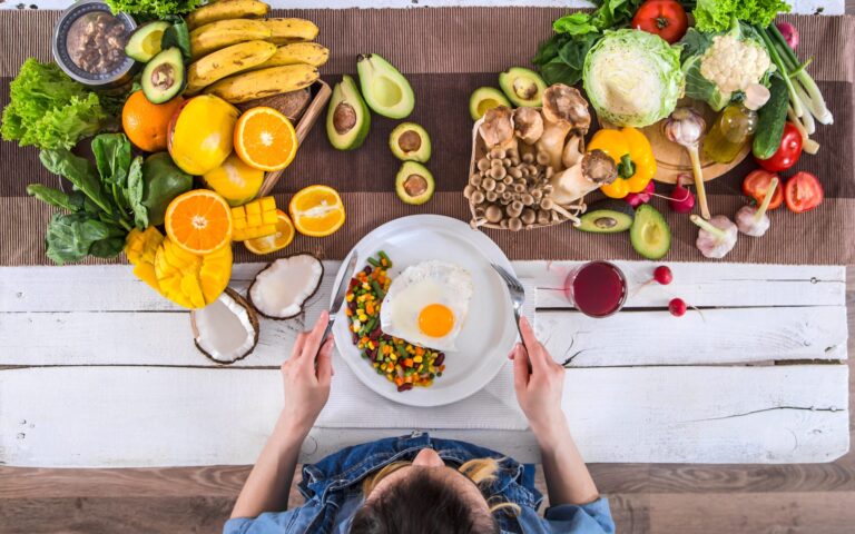 The woman at the dinner table with organic food , the view from the top.